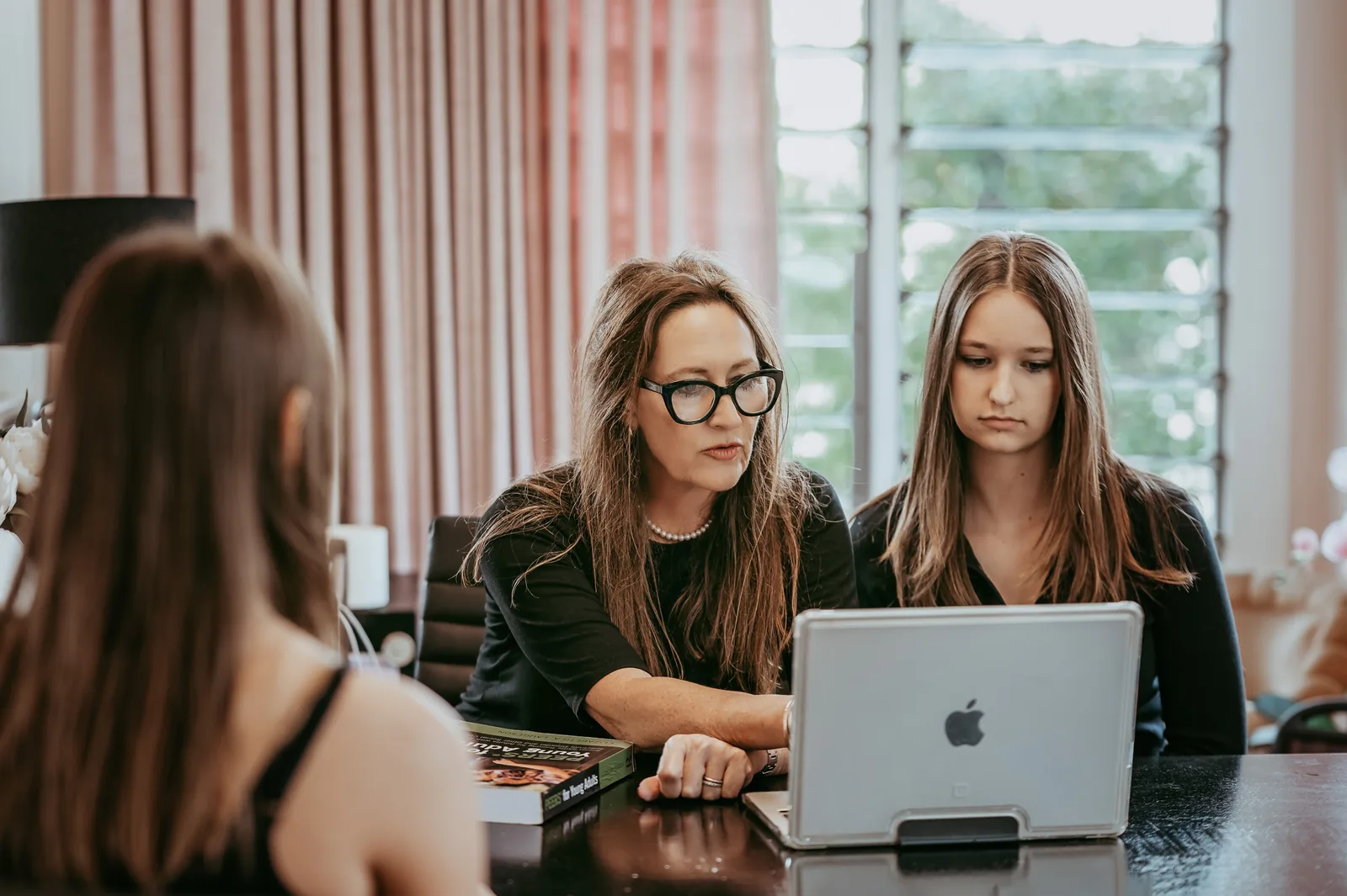 Edwina working with a young adult client at a desk during a session